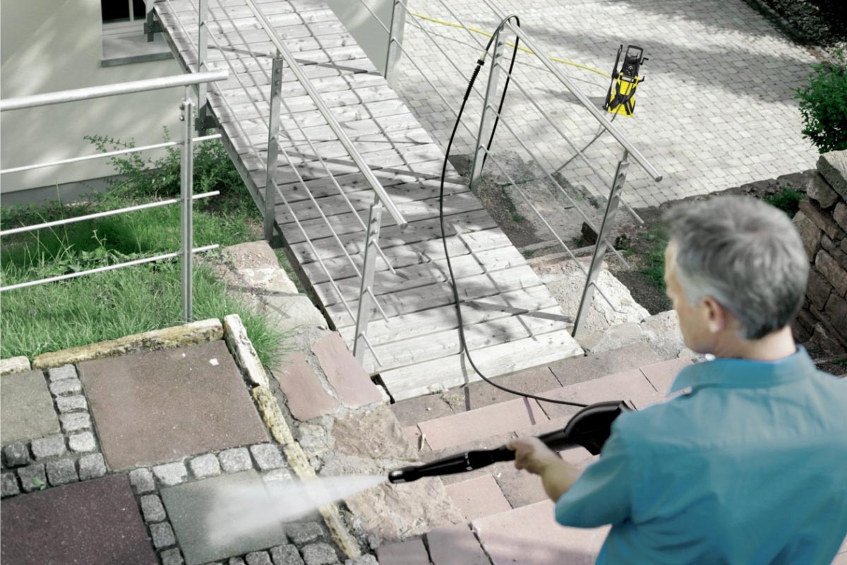 Prodlužovací hadice vysokotlakého čističe 10m pro K 3 - K 7 od společnosti Karcher Prodlužovací hadice vysokotlakého čističe 10m pro K 3 - K 7 od společnosti Karcher. Muž myjící schody. Mezi pistolí a čističem je připojena prodlužovací vysokotlaká hadice.